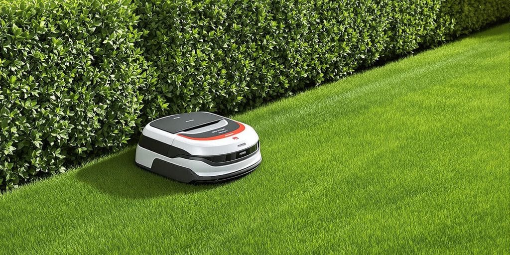 Honda Miimo Multi i en grön trädgård som klipper häckar.